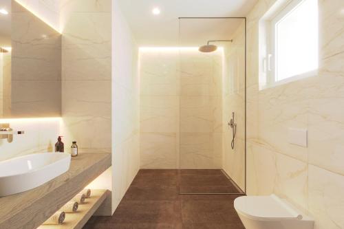 a bathroom with a shower and a sink and a toilet at Maj Luxury Residence in Poreč