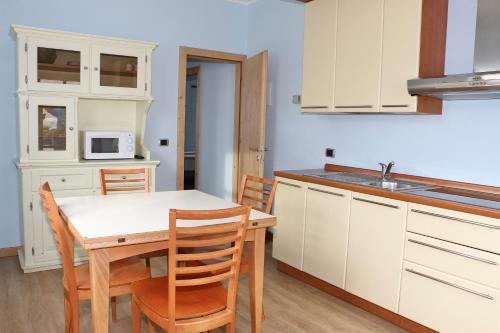 a kitchen with a table and chairs and a microwave at Appartamenti Forhotel in Livigno
