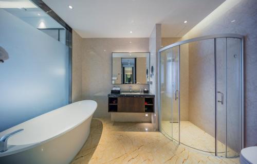 a bathroom with a tub and a sink at Forest City Golf Hotel in Nusajaya
