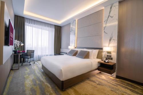 a hotel room with a large bed and a desk at St Giles Southkey in Johor Bahru