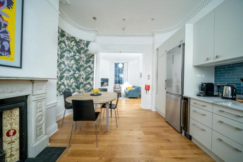 - une cuisine et une salle à manger avec une table et des chaises dans l'établissement JOIVY Modern 4 bed flat with communal courtyard in Angel, East London, à Londres