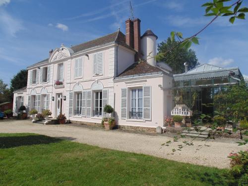 a large white house with a greenhouse in front of it at Clos Saint Nicolas in Neauphle-le-Château