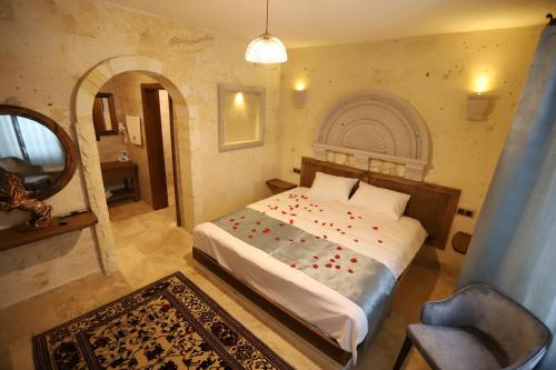 a bedroom with a bed and a chair and a mirror at Castle Panorama House in Nevsehir