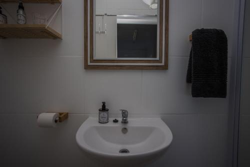 a bathroom with a white sink and a mirror at HIGH LEVEL 26 in Agulhas