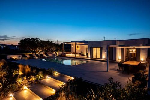 una casa con piscina por la noche en Villa Paraga en Platis Yialos Mykonos