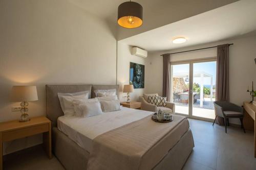 a bedroom with a large bed and a balcony at Villa Paraga in Platis Yialos Mykonos