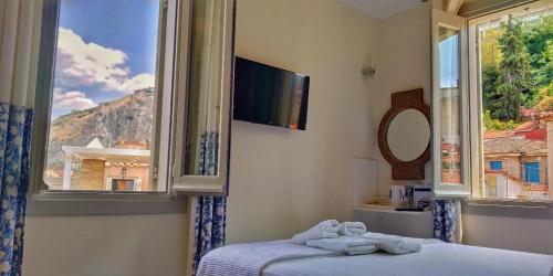 a bedroom with a bed and a large window at Gambello Luxury Rooms in Nafplio