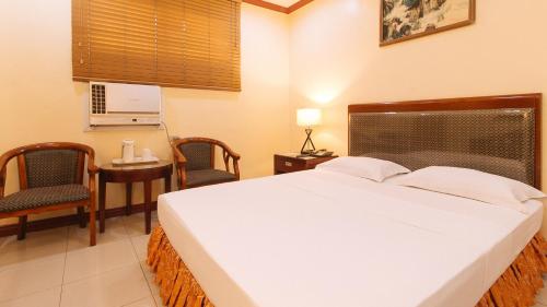 a bedroom with a bed and a table and chairs at Peace Hotel by RedDoorz in Manila