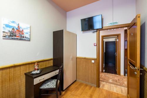 Pokój z biurkiem i telewizorem na ścianie w obiekcie Mini-hotel Solotel w Moskwie