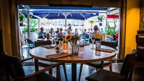 a table in a restaurant with people sitting at tables at Hotel Brasserie de Huifkar in Middelburg