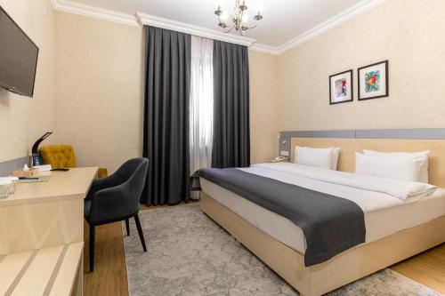 Habitación de hotel con cama y escritorio en Navruz Hotel Tashkent, en Tashkent