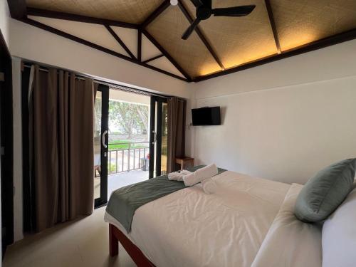 a bedroom with a bed with a ceiling fan at DIANAO BEACH CLUB AND RESORT in Dilasag