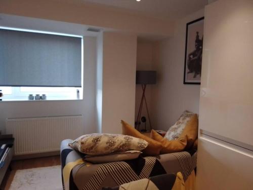 a living room with a couch and a window at Whole apartment 5 mins to East Croydon & concierge in London