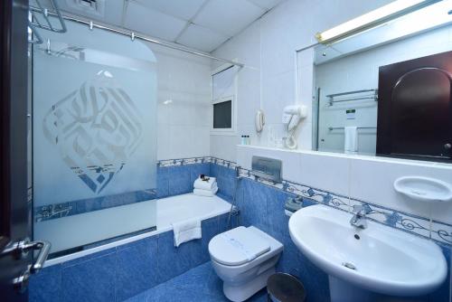 a bathroom with a sink and a toilet and a mirror at Emirates Stars Hotel Apartments Dubai in Dubai