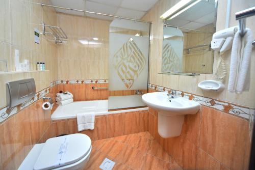 a bathroom with a sink and a toilet and a mirror at Emirates Stars Hotel Apartments Dubai in Dubai