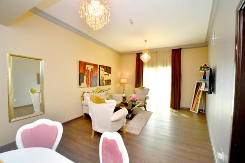 a living room with white chairs and a table at Emirates Stars Hotel Apartments Dubai in Dubai