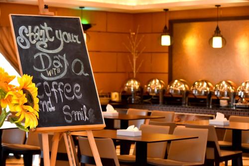 a chalkboard sign in a restaurant with tables and chairs at Emirates Stars Hotel Apartments Dubai in Dubai