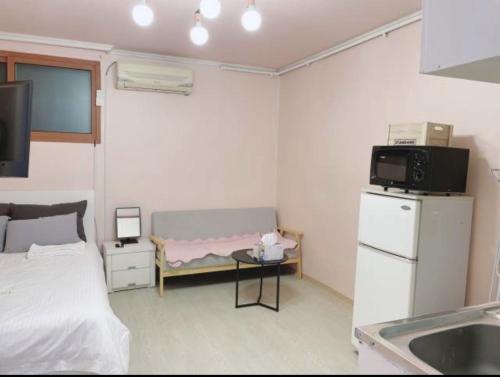 a small room with a bed and a table with a tv at Ellen House in Seoul