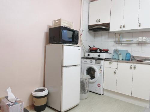 a small kitchen with a refrigerator and a microwave at Ellen House in Seoul