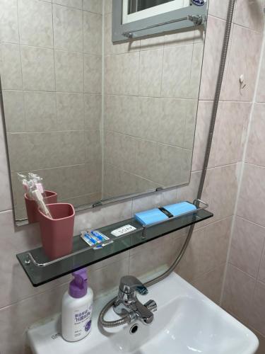 a bathroom with a sink with a mirror and a toothbrush at Ellen House in Seoul