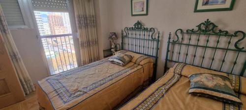 1 dormitorio con 2 camas y ventana en Las Damas, en Benidorm