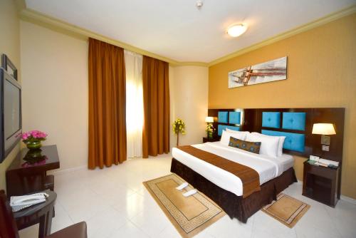 a hotel room with a bed and a television at Emirates Stars Hotel Apartments Dubai in Dubai