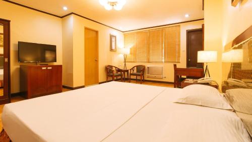 a hotel room with a bed and a television at Peace Hotel by RedDoorz in Manila