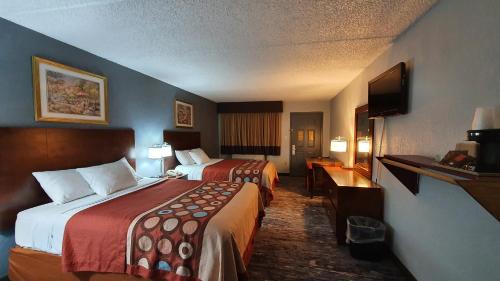 a hotel room with two beds and a flat screen tv at South Padre Island Inn in South Padre Island