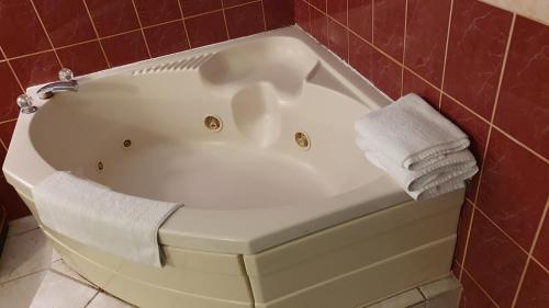 uma banheira branca com toalhas por cima em South Padre Island Inn em South Padre Island