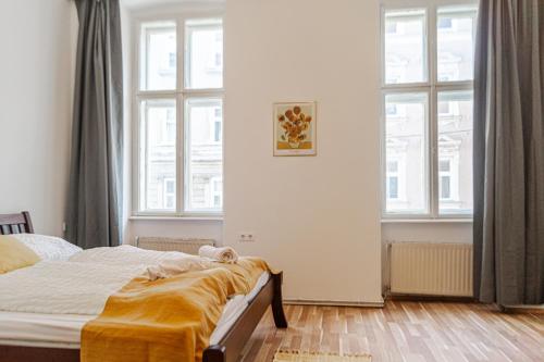 a bedroom with a bed and two large windows at Pleasant 3BR City Stay near Event Location Wiener Stadthalle in Vienna