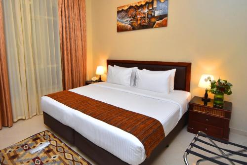 a bedroom with a large bed in a hotel room at Emirates Stars Hotel Apartments Sharjah in Sharjah