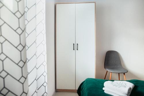 a bedroom with a green bed and a chair at Przystanek Roztocze in Susiec