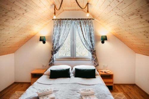 a bedroom with a large bed and a window at Przystanek Roztocze in Susiec