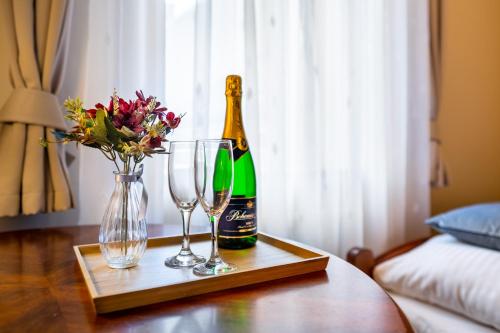 butelkę szampana i dwa kieliszki na stole w obiekcie Hotel Garni Na Havlíčku w mieście Kutná Hora