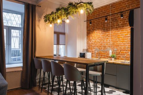 a kitchen with a wooden table with chairs and a brick wall at Caps Hotel на Остоженке in Moscow