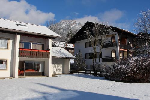 een huis met sneeuw op de grond ervoor bij Ferienwohnung Keßler in Bad Hindelang