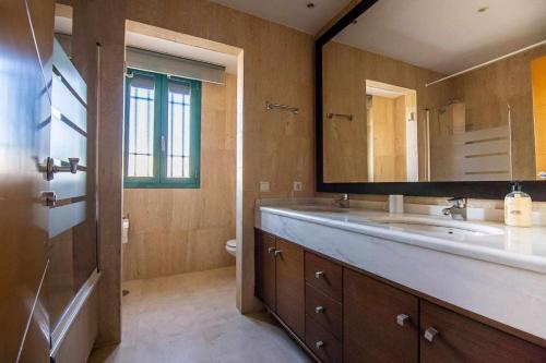 a bathroom with a sink and a mirror at Modern beach villa with parking and private pool in Torremolinos