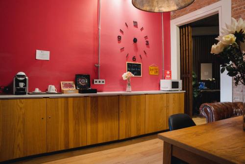 um balcão com um relógio em uma parede vermelha em Cosmopolitan Boutique Rambla em Barcelona