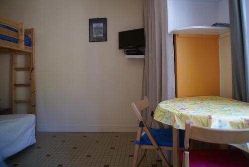 クルル・シュル・メールにあるAu Coeur de Bourg CSMのテーブル、椅子、ベッドが備わる客室です。
