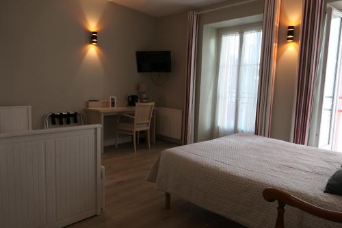 Schlafzimmer mit einem Bett, einem Schreibtisch und einem Tisch in der Unterkunft Hotel Kapa Gorry in Saint-Jean-de-Luz