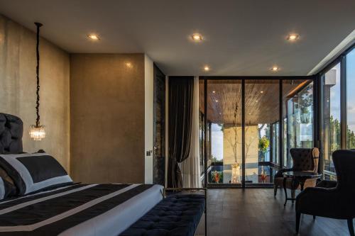 a bedroom with a bed and a view of a balcony at VILLA GIMA 1 - 5 bedroom UMALAS in Kerobokan