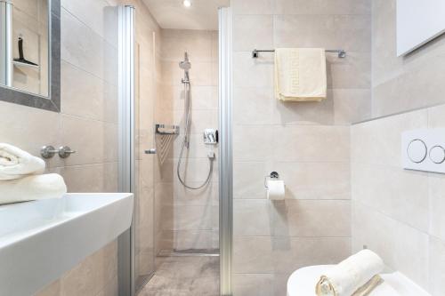 un bagno con doccia, WC e lavandino di Gasthof Pension Berghof a Hippach