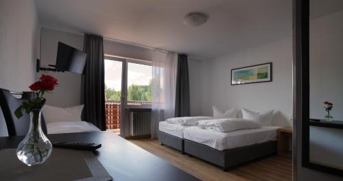 ガイゼルヴィントにあるHotel Gasthof Metzgerei Lammのベッドルーム1室(ベッド1台、テーブルの上に花瓶1枚付)