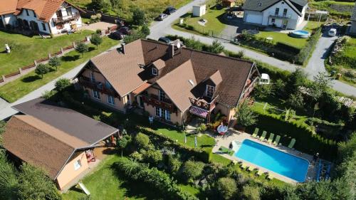 伏爾塔瓦河畔利普諾的住宿－Apartments Lipno Serafin，享有带游泳池的房屋的空中景致