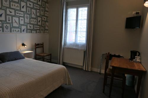 een slaapkamer met een bed, een bureau en een raam bij Hotel Kapa Gorry in Saint-Jean-de-Luz