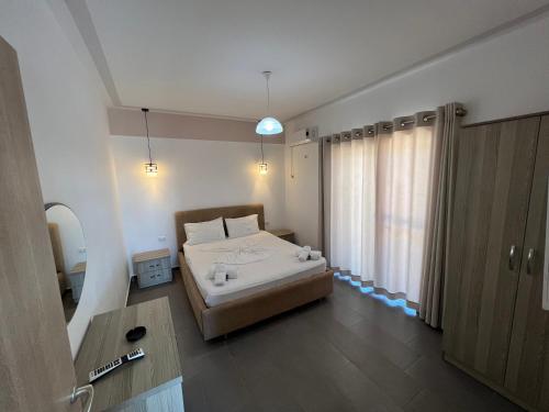 a bedroom with a bed and a large window at Hotel Irini in Sarandë