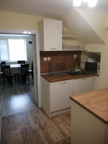 a kitchen with white cabinets and a dining room at дом Тодор и Тота Мутевски in Troyan