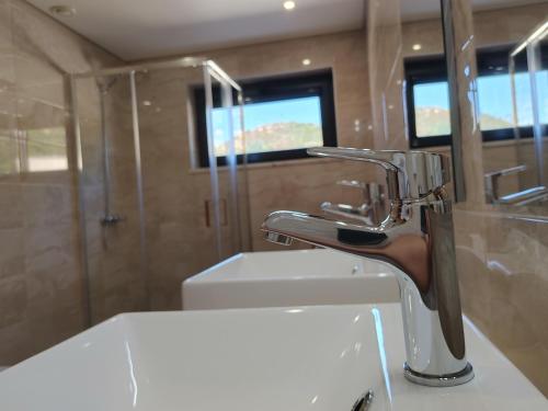 a bathroom with a sink and a faucet at Lago Azul Villas in Ferreira do Zêzere