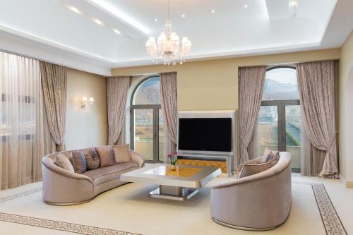 a living room with two couches and a tv at Gabala Garden Hotel in Gabala