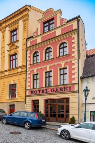 two cars parked in front of a hotel grant at Hotel Garni Na Havlíčku in Kutná Hora